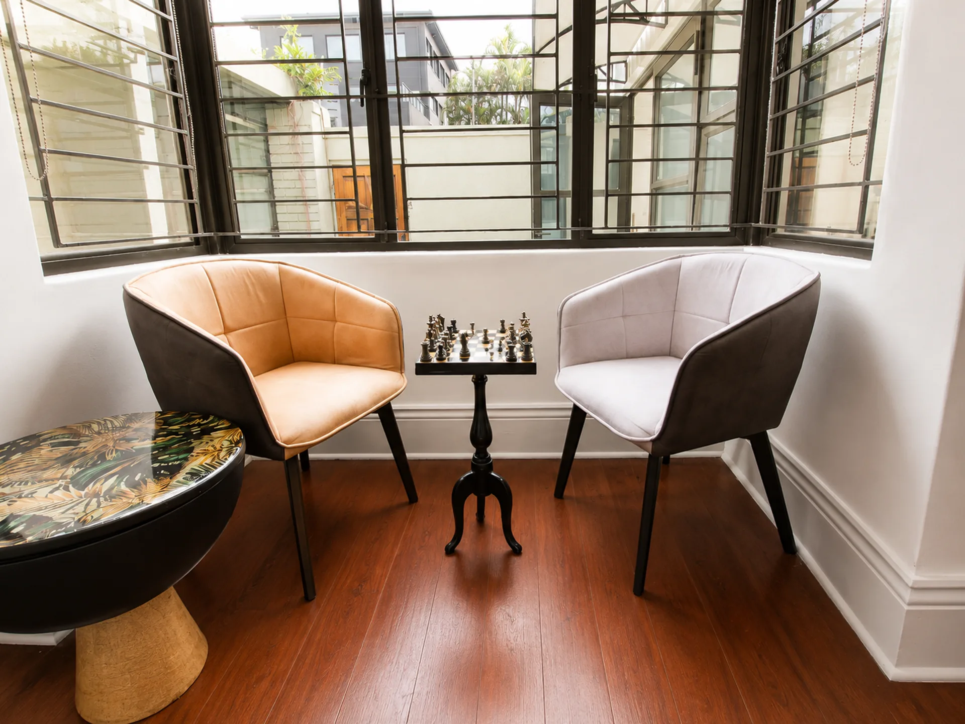Two armchairs either side of a pedestal table set with a chess board, Musgrave Escape, Durban, managed by EZStay